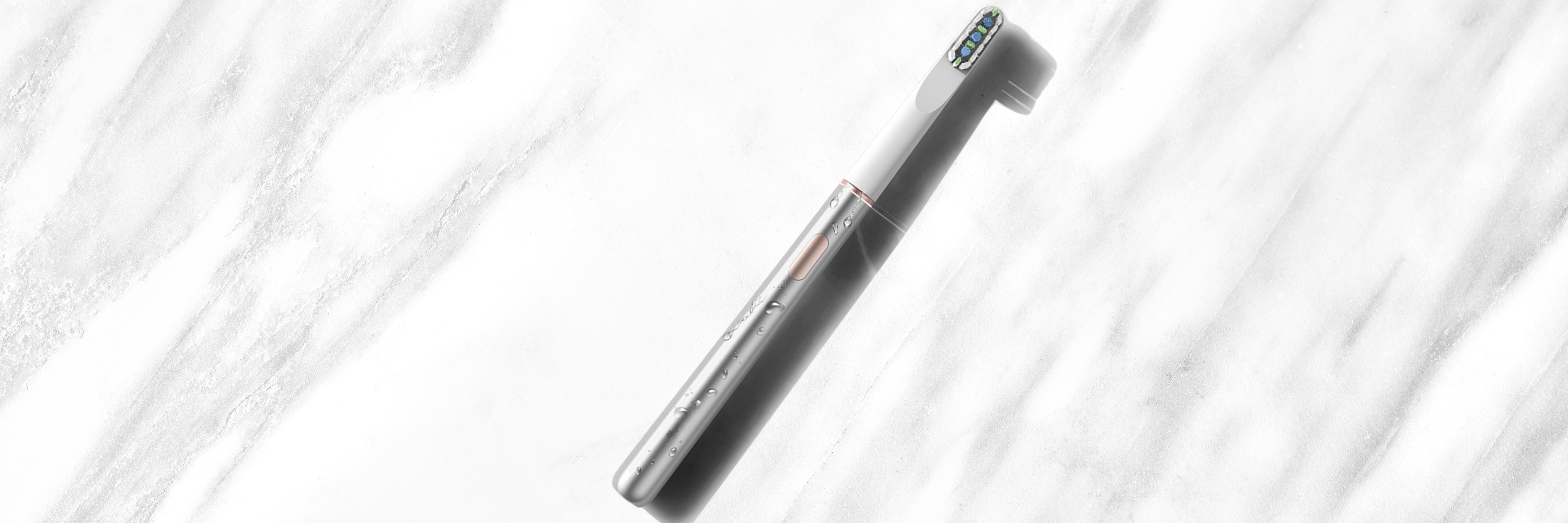 A birds-eye view of our iconic silver Ultra Sonic brush glistening on a marble counter.